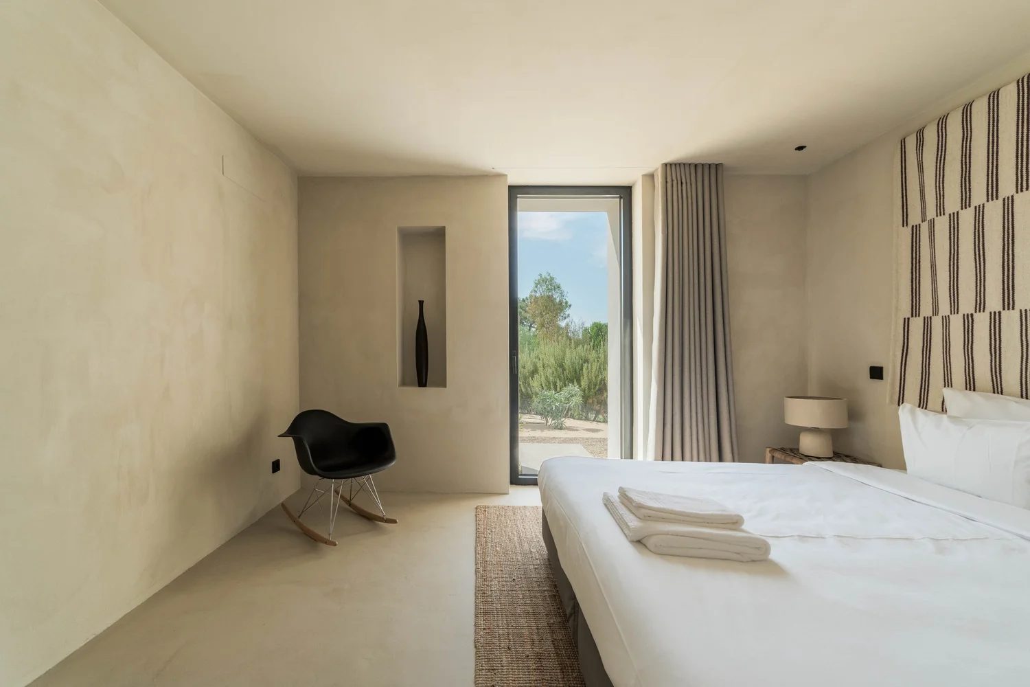 Quarto minimalista com vista para o jardim
